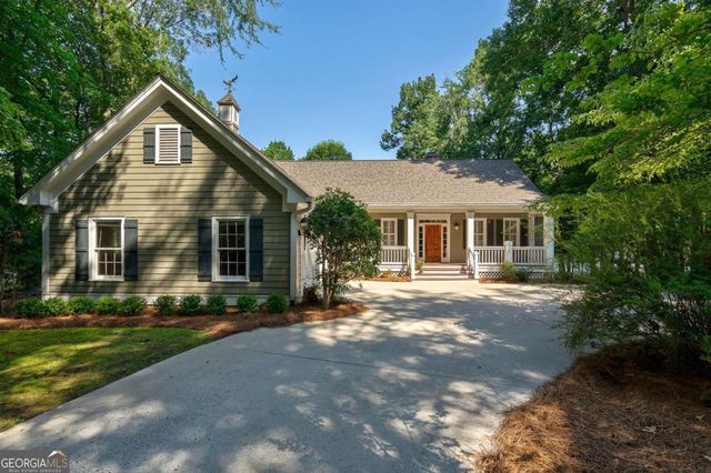 a front view of a house with a yard and green space