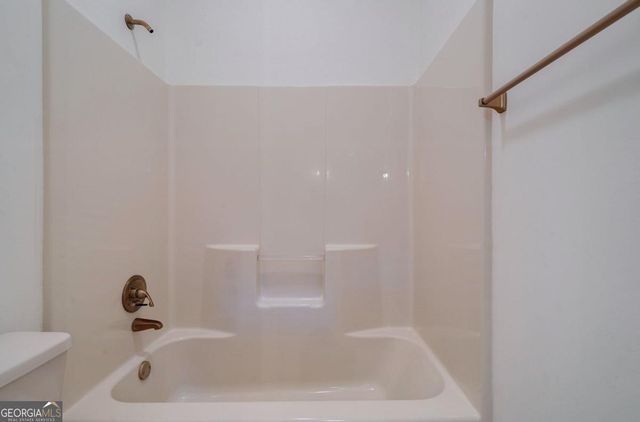 a view of a hallway with wooden floor and a kitchen