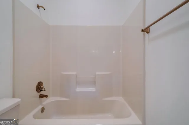a view of a hallway with wooden floor and a kitchen