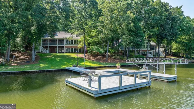a view of swimming pool with lawn chairs and plants