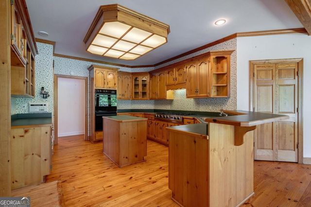 a kitchen with stainless steel appliances granite countertop a stove a sink and dishwasher cabinets with wooden floor