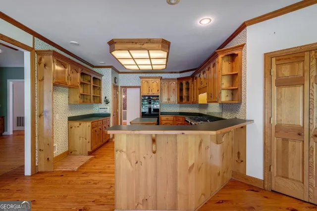 a kitchen with stainless steel appliances granite countertop a sink a stove and wooden floors