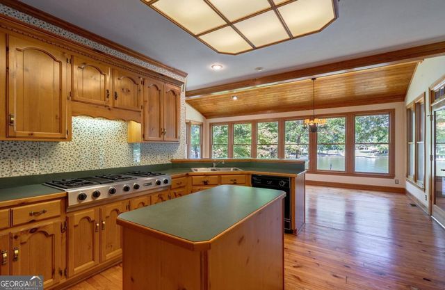 a view of a big room with wooden floor and a kitchen