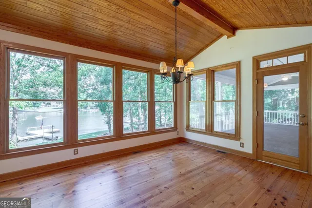 a view of hallway with wooden floor and a window