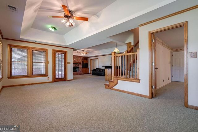 an empty room with a ceiling fan and a window