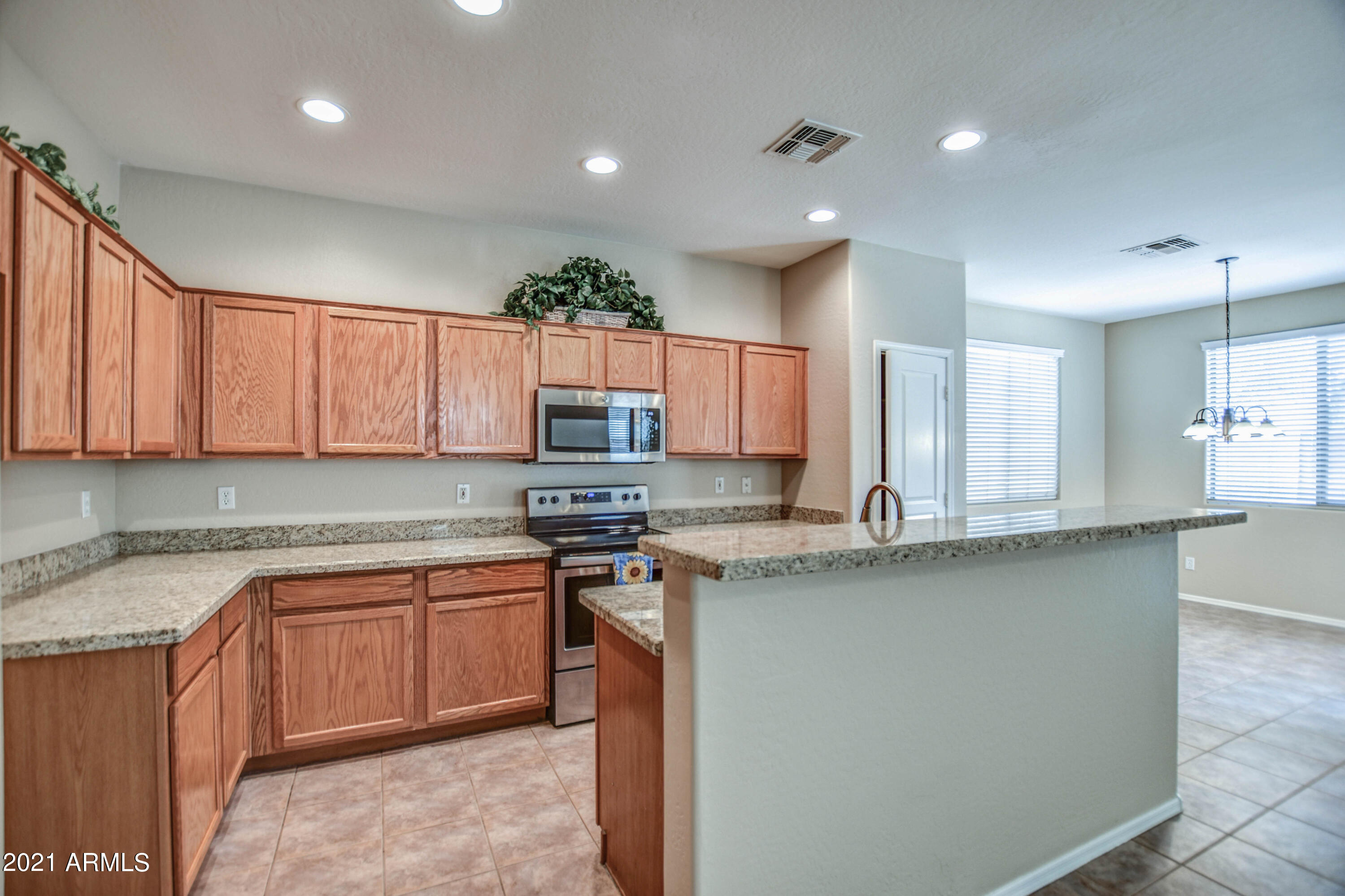 3787 East Chickadee Road Gilbert, AZ 85297 - Photo 3 of 41 a kitchen with stainless steel appliances granite countertop a sink a stove top oven a counter space and cabinets