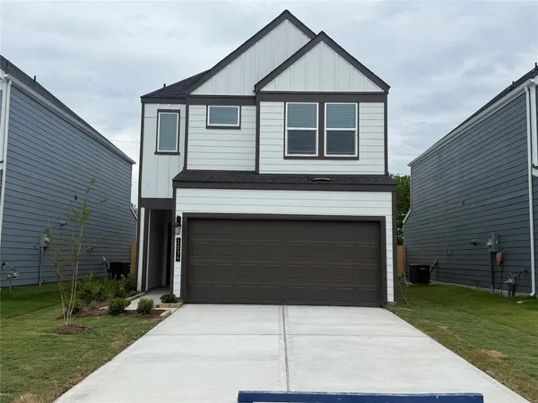 a front view of a house with a garden and yard