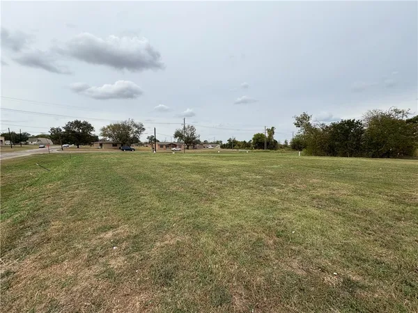 a view of a field with an trees in front of it