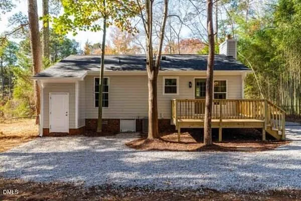 a view of a house with a yard and large tree