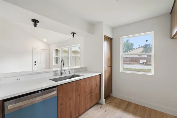 a kitchen with a sink cabinets and wooden floor