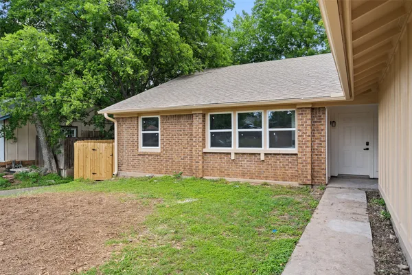 a view of a house with backyard and sitting area