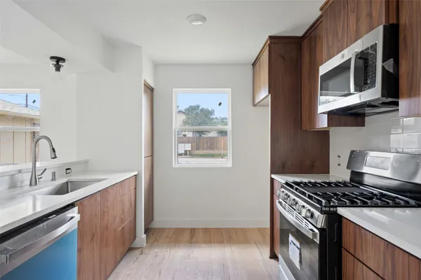 a kitchen with stainless steel appliances granite countertop a stove and a microwave