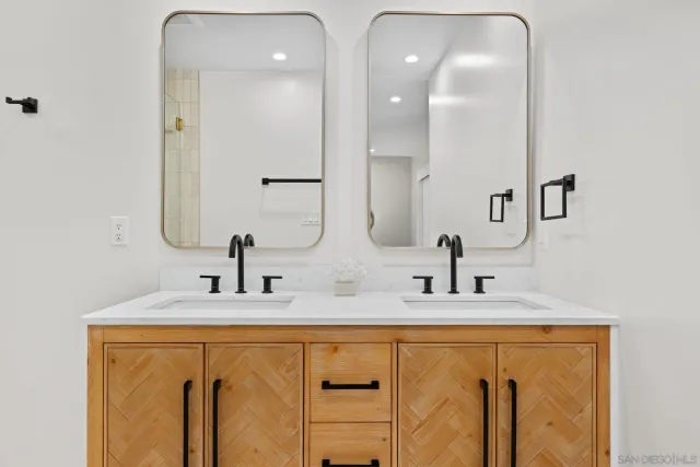 a bathroom with double vanity sinks and a mirror