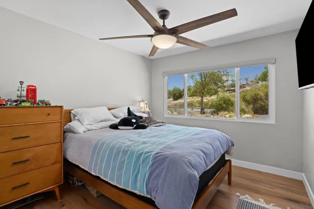 a bedroom with a bed and a flat tv screen on dresser