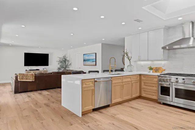 a kitchen with stainless steel appliances kitchen island granite countertop a stove top oven and sink