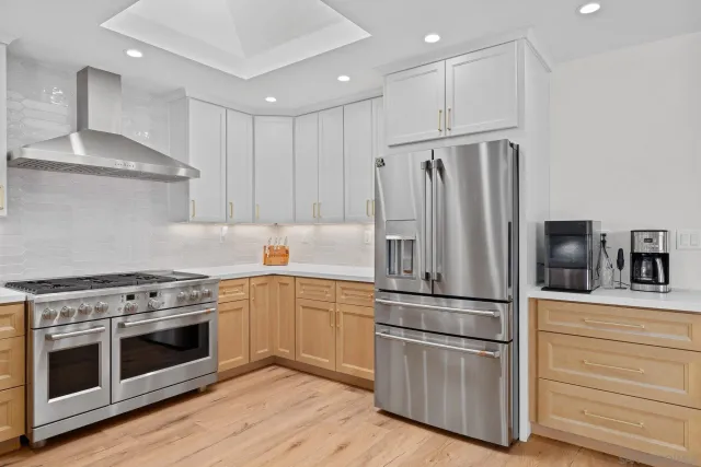 a kitchen with granite countertop stainless steel appliances and wooden floor