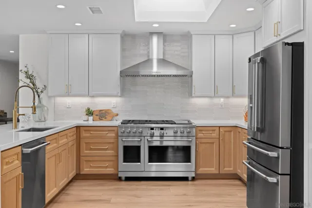 a kitchen with stainless steel appliances kitchen island granite countertop a stove a refrigerator and a sink with cabinets