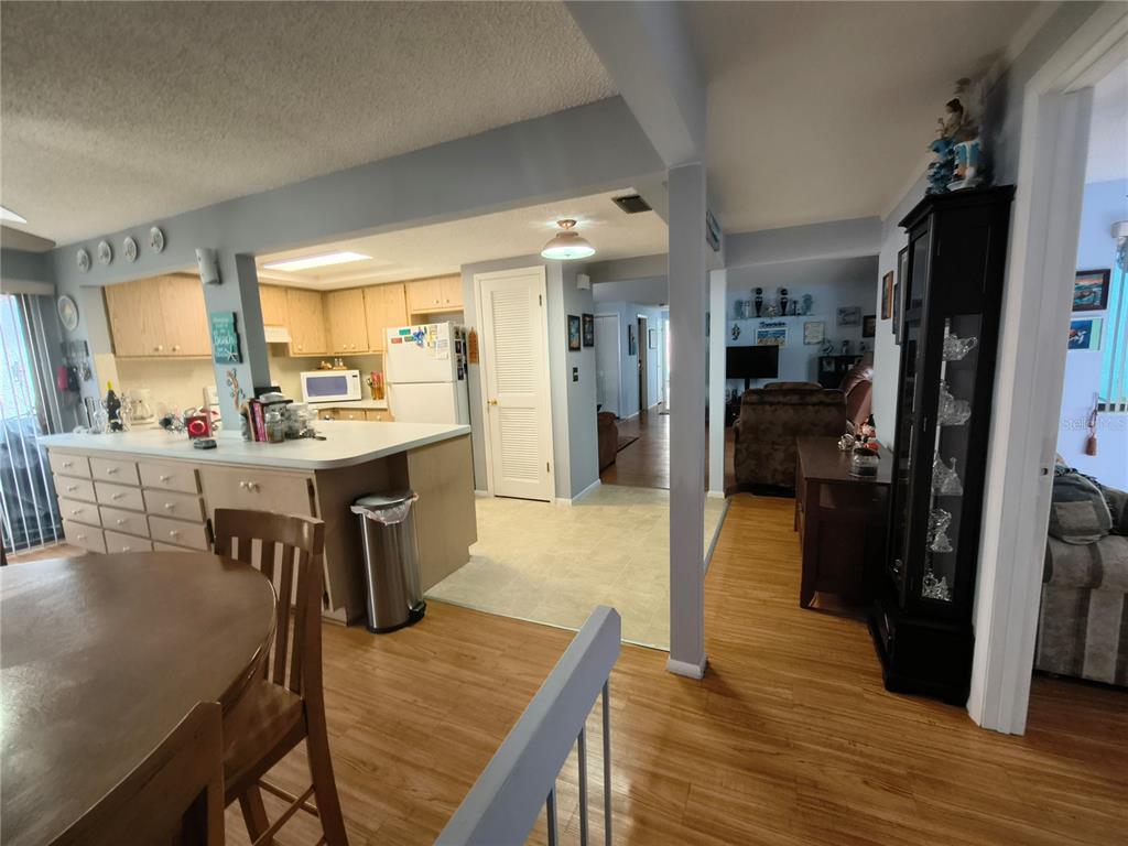 7519 Clanton Trail Hudson, FL 34667 - Photo 20 of 83 a open dining room with stainless steel appliances kitchen island granite countertop a table chairs and a refrigerator