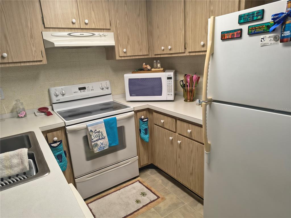7519 Clanton Trail Hudson, FL 34667 - Photo 21 of 83 a kitchen with a refrigerator a stove a microwave and cabinets