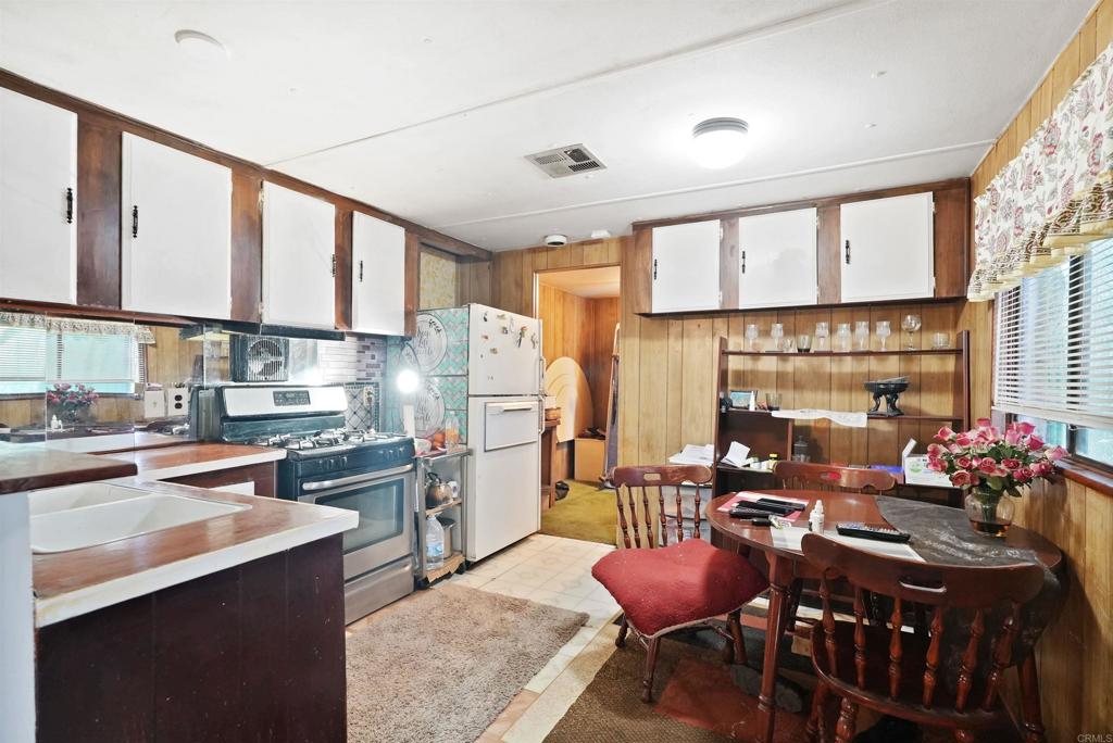 40645 Sage Road Hemet, CA 92544 - Photo 7 of 70 a kitchen with refrigerator cabinets table and chairs