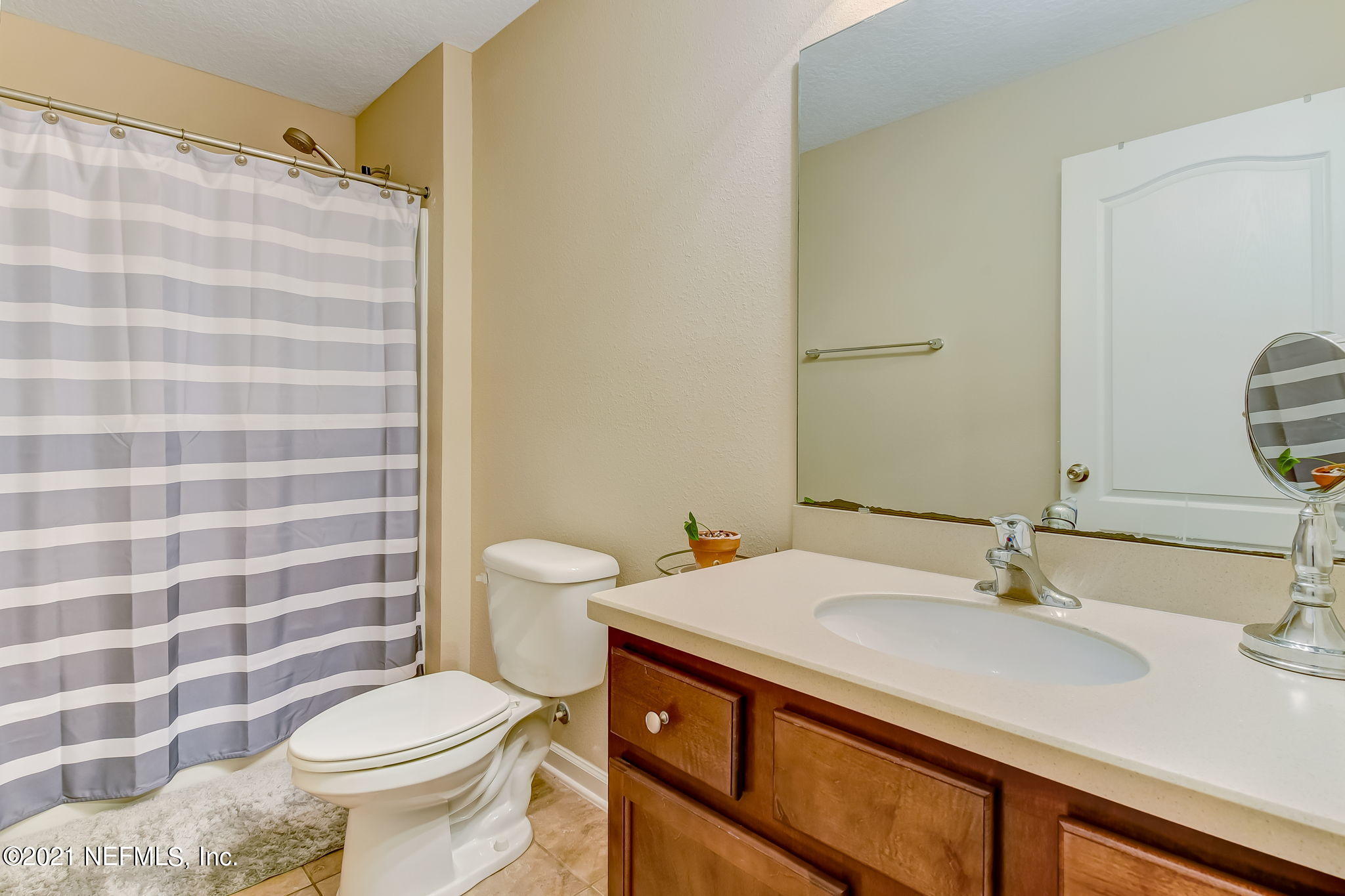 97254 Bluff View Circle Yulee, FL 32097 - Photo 20 of 34 a bathroom with a sink a toilet a mirror and shower curtain