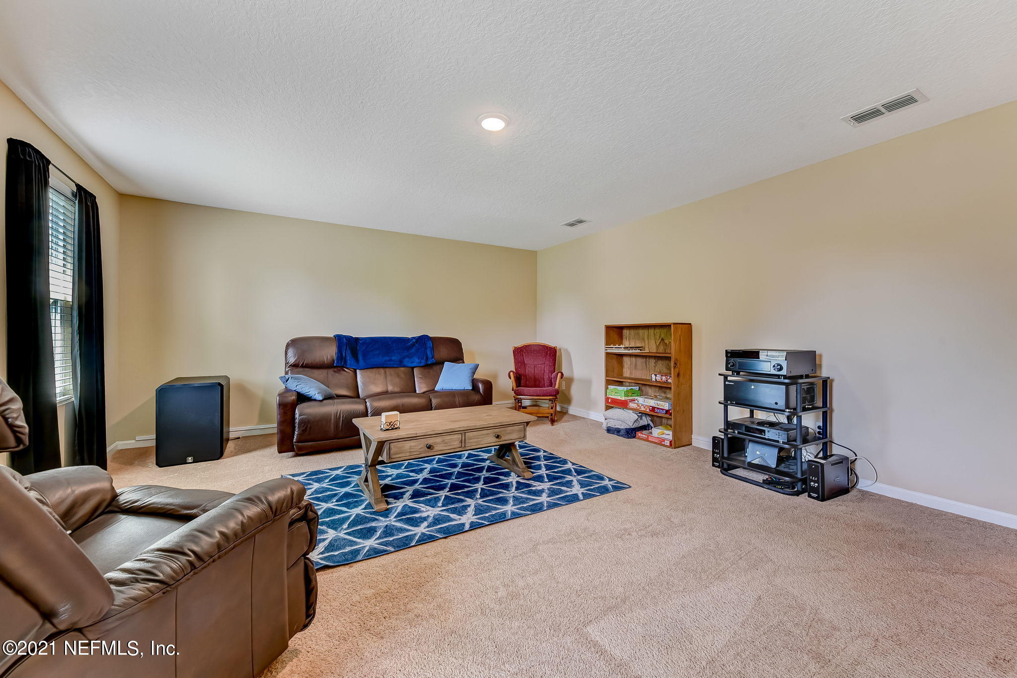 97254 Bluff View Circle Yulee, FL 32097 - Photo 24 of 34 a living room with furniture and a flat screen tv