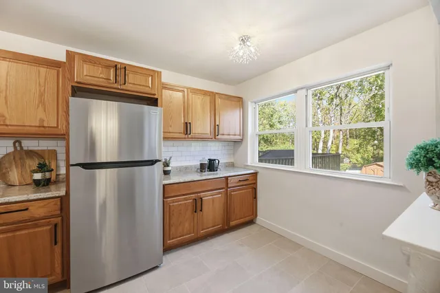 a kitchen with stainless steel appliances granite countertop a refrigerator a sink a stove a washer and cabinets