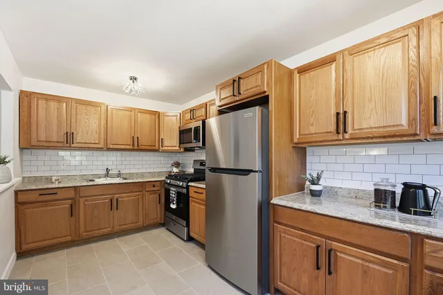 a kitchen with stainless steel appliances granite countertop a refrigerator sink and cabinets