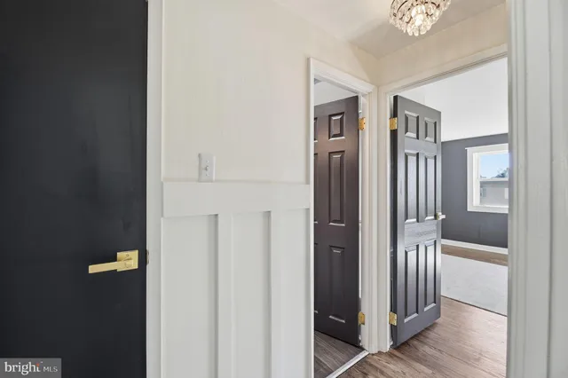 a view of a hallway with wooden floor and living room