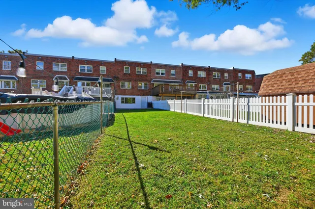 a view of a garden with a bench in front of house