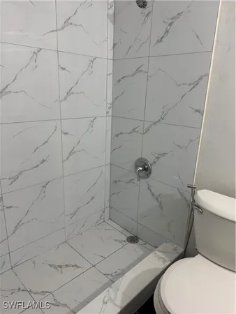 a bathroom with a toilet and a shower