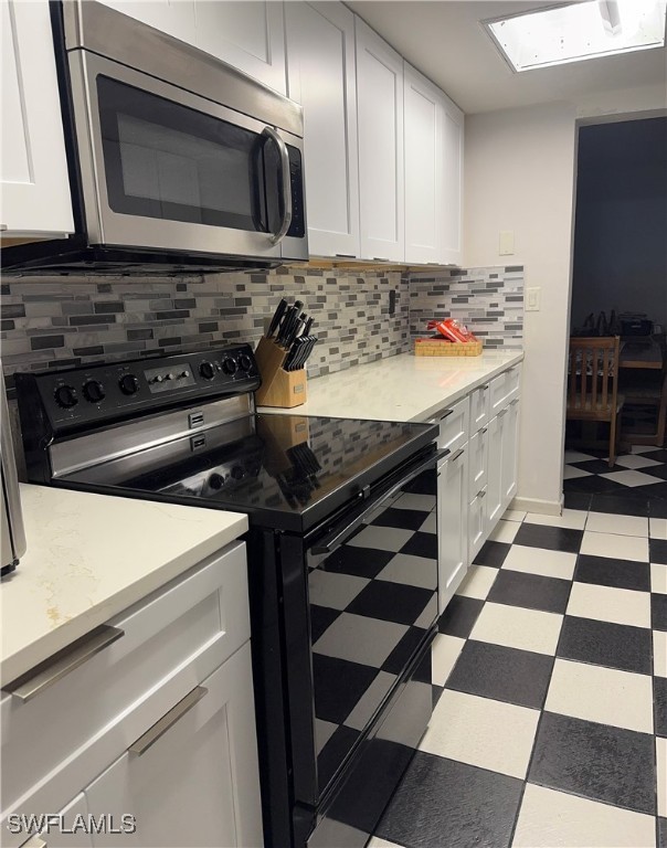806 West 80th Place Hialeah, FL 33014 - Photo 16 of 17 a kitchen with a stove a microwave and cabinets