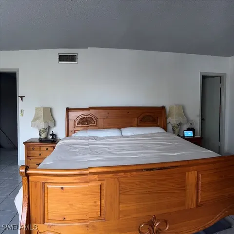 a bedroom with a bed and a painting on the wall