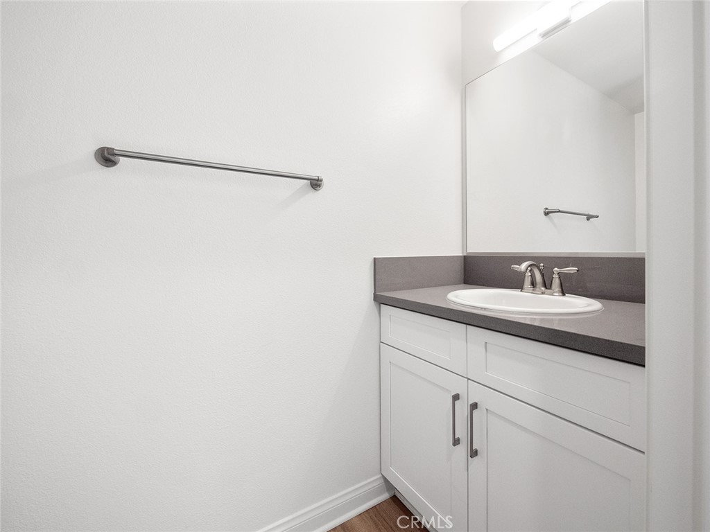 1325 West Grand Avenue, Unit 3 Pomona, CA 91766 - Photo 11 of 30 a bathroom with a granite countertop sink and a mirror