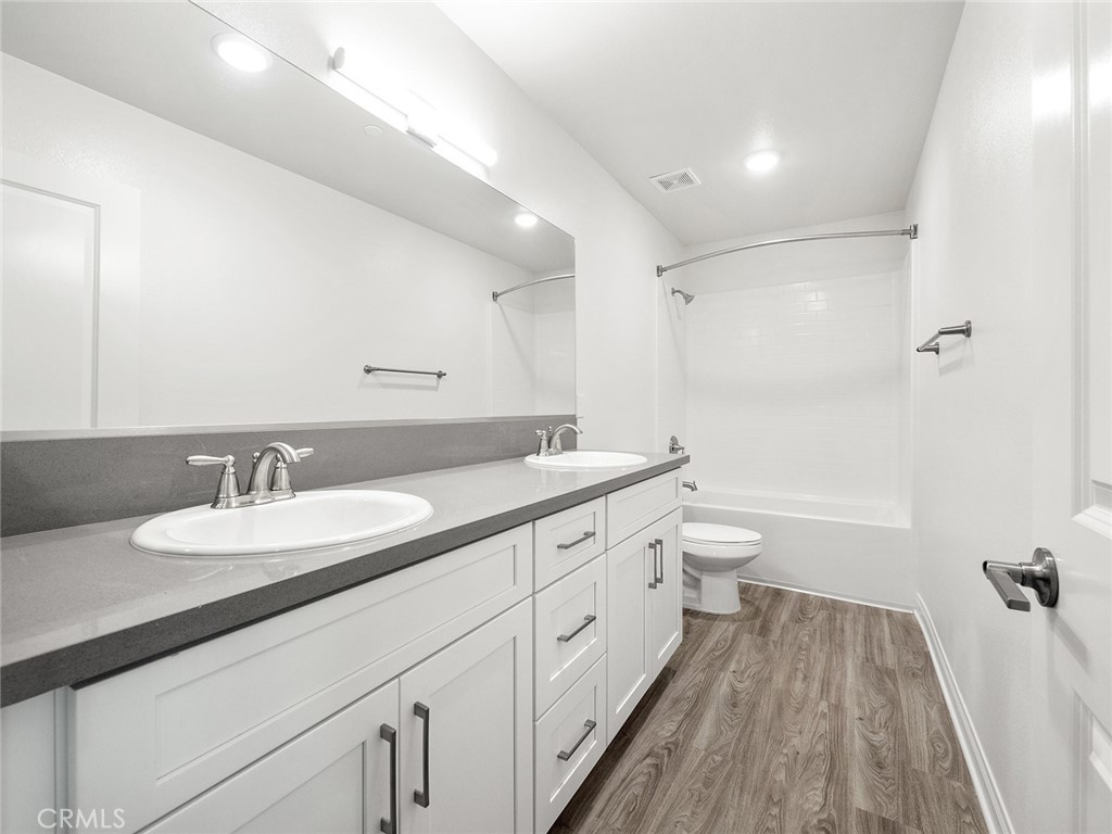 1325 West Grand Avenue, Unit 3 Pomona, CA 91766 - Photo 15 of 30 a spacious bathroom with a granite countertop sink a toilet a mirror and shower