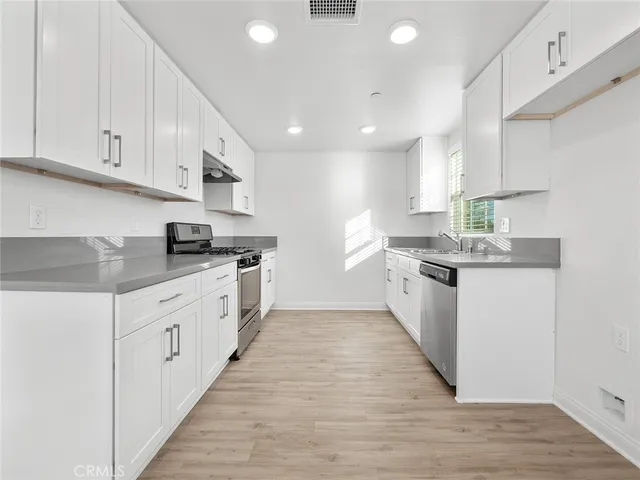 a kitchen with granite countertop a stove and a sink