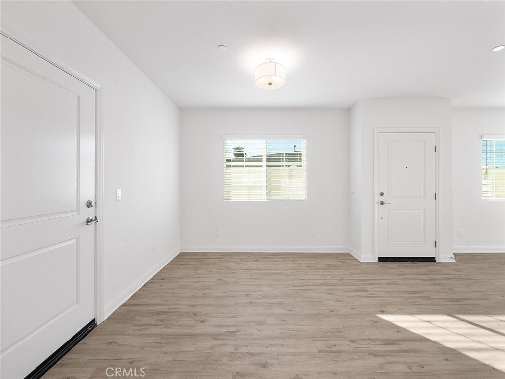 1325 West Grand Avenue, Unit 3 Pomona, CA 91766 - Photo 6 of 30 a view of an empty room with wooden floor and a window