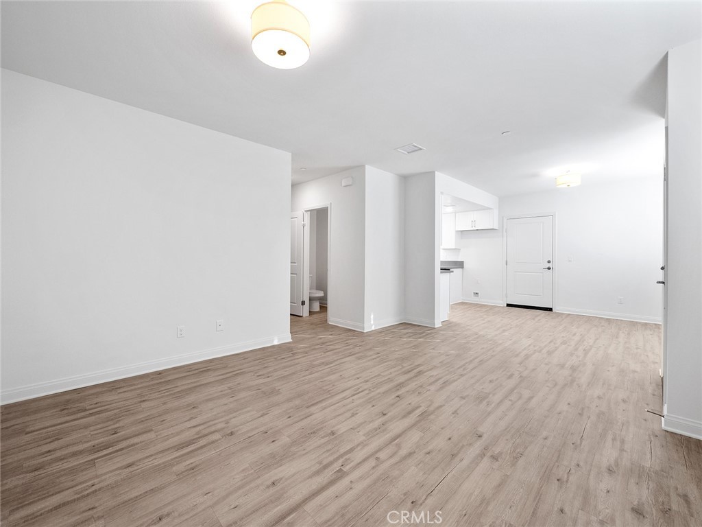 1325 West Grand Avenue, Unit 3 Pomona, CA 91766 - Photo 10 of 30 a view of an empty room and wooden floor