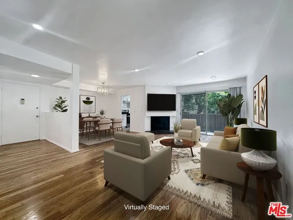 a living room with furniture wooden floor and a flat screen tv