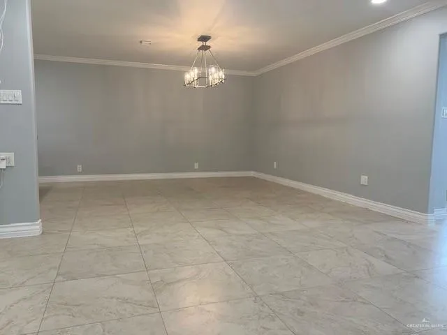 a view of an empty room with a chandelier fan