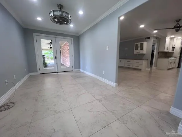 an empty room with windows and chandelier