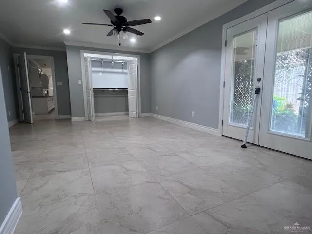 a view of a livingroom with a chandelier fan and windows