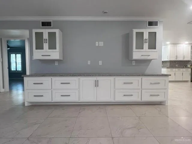 a kitchen with granite countertop white cabinets and sink
