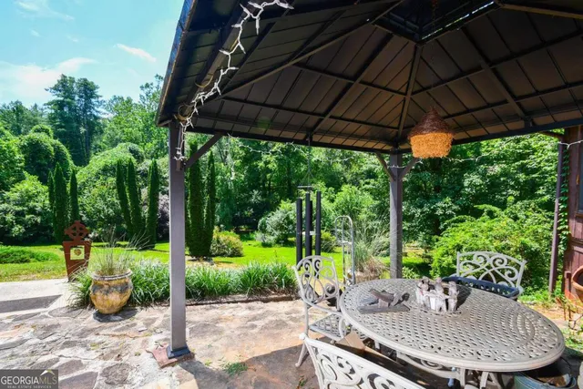 a view of a patio with table and chairs under an umbrella