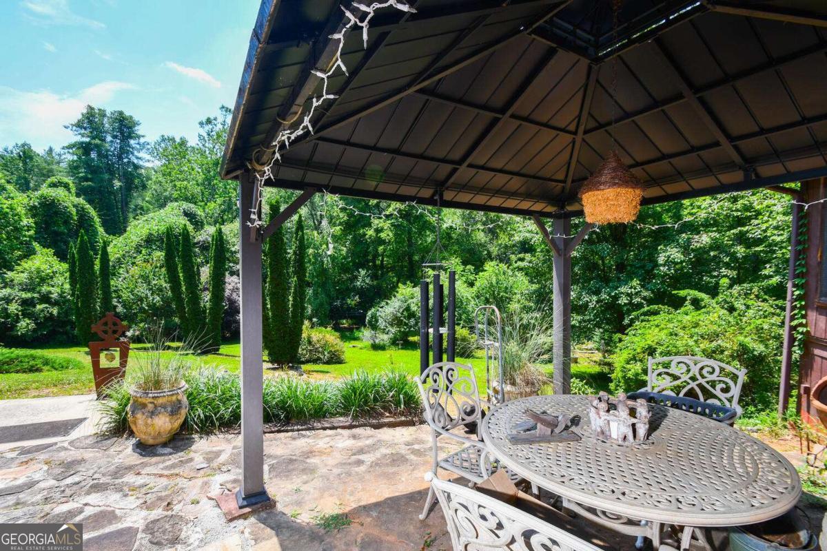 501 The Orchard Road Clarkesville, GA 30523 - Photo 6 of 20 a view of a patio with table and chairs under an umbrella