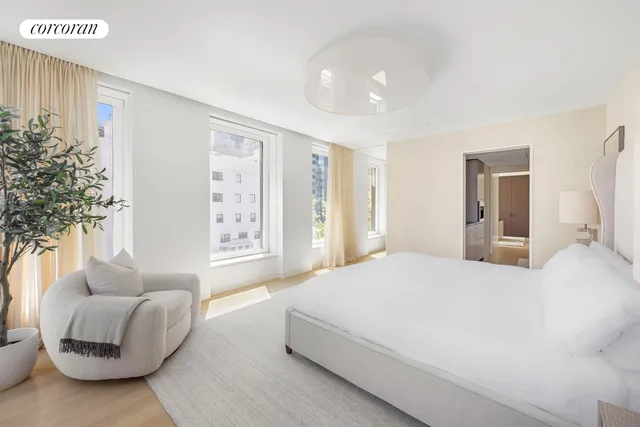 a living room with furniture a rug kitchen view and a window