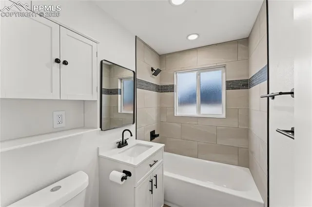 a bathroom with a bathtub shower sink and toilet