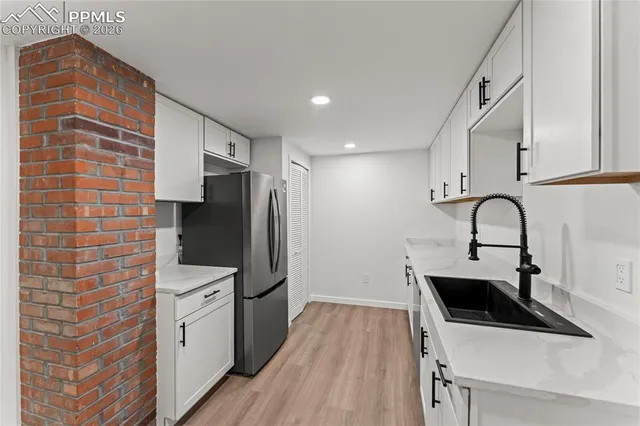 a kitchen with a sink a refrigerator and cabinets
