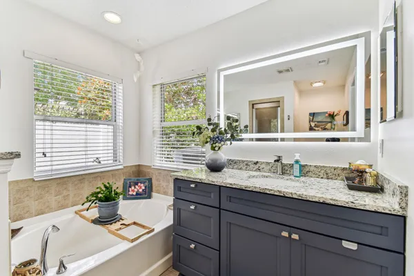 a bathroom with a granite countertop toilet sink and mirror