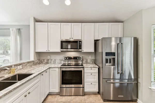 a kitchen with stainless steel appliances a stove a sink refrigerator and cabinets